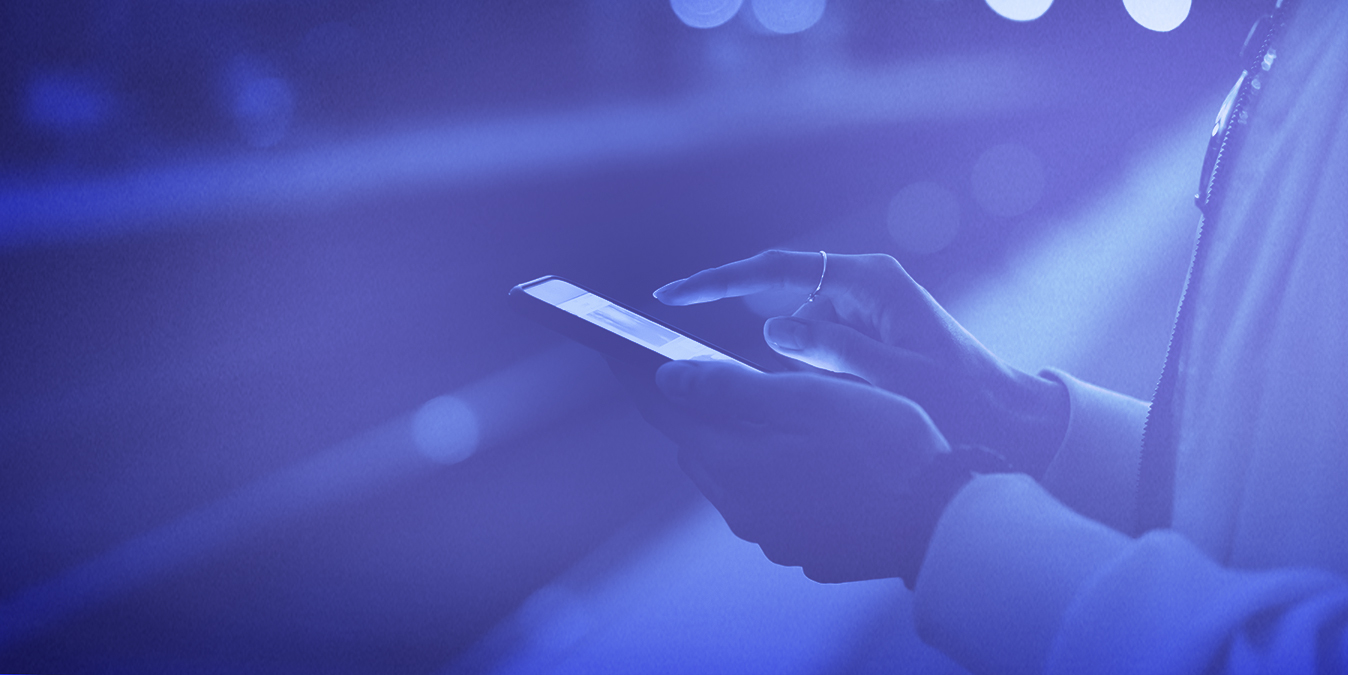 Hand of a woman using a smartphone waiting for a train