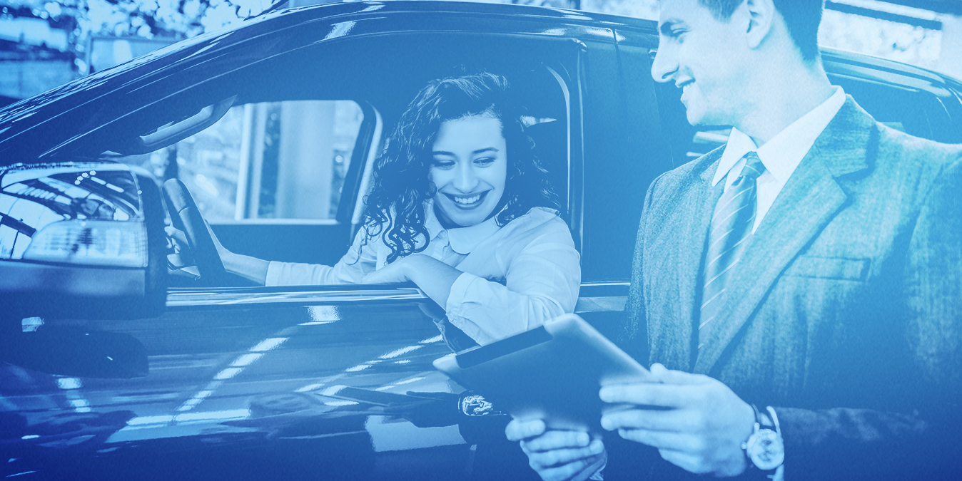 Man holding a tablet talking to a woman in a car